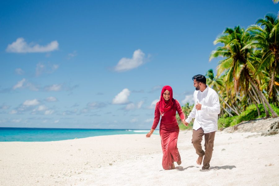 Couple walking on beach in Maldives