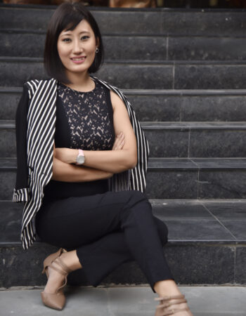 Seldon Tenzing lifestyle shot sitting on stairs in professional attire.